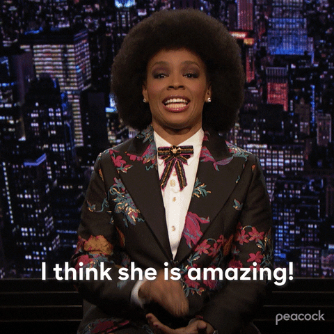 TV gif. Amber Ruffin on the Amber Ruffin Show claps her hands together as she speaks, leaning into the final clap as she says, "I think she is amazing!"