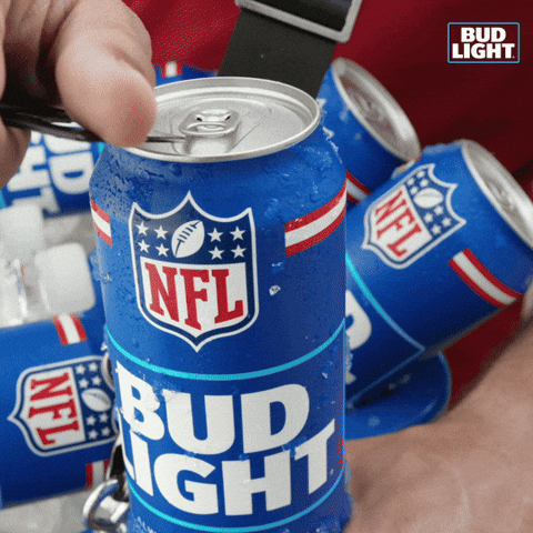 Sponsored gif. A hand uses an opener to pop the top on an NFL themed can of Bud Light. Several more cans of Bud Light are in the background. 