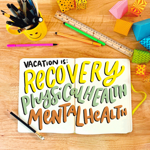 Text gif. Notebook with shimmering text "Vacation is: recovery, physical health, mental health" sits on a desk surrounded by art supplies. A ruler lays above the notebook next to a yellow cup with a smiley face on it that is filled with pens and markers. Colorful blocks are strewn on the desk above the ruler.