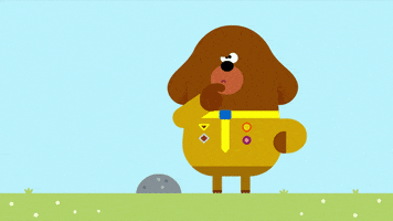 Cartoon gif. Duggee the brown dog in hey Duggee stands next to a rock. He looks up with a quizzical expression and scratches his chin as he thinks.