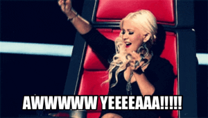 Reality TV gif. Christina Aguilera on the Voice dances while she sits in her seat. She rolls her body and lifts her arms in the air, feeling the music. The text is a long drawn out, “awwww Yeaaaa!!!!!”