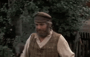 Movie gif. Chaim Topol as Tevye in Fiddler on the Roof walks down a road, holding a silver pot. He swings the pot up and rests it on a wall, and leans onto it. He looks at us, saying, “I'll tell you! I don't know.” and walks away. 
