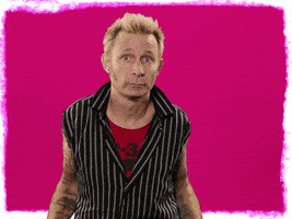 Celebrity gif. Mike Dirnt of Green Day looks at us with open arms, shrugging. Text, "Whatever."