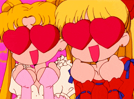 Anime gif. Sailor Moon and Sailor Venus’s eyes are big red hearts and they smile widely with their hands balled up in excitement under their chins.