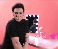 Video gif. Manny MUA sits at a small desk with a makeup mirror on it, turned towards us with a hand in his lap. He looks at us with excitement as he says, "I know right?" and then looks up with a blissful smile. 