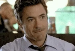 trying not to laugh robert downey jr GIF