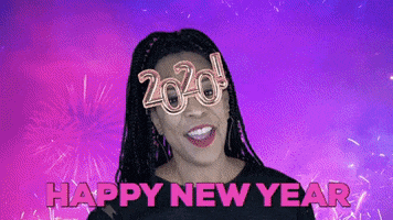 Video gif. A woman wearing glasses that read "2020!" dances and waves her arm excitedly in the air as fireworks explode behind her against a colorful blue and purple background. Text, "Happy New Year"
