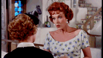 Movie gif. Maureen O'Hara as Maggie in The Parent Trap. She gasps and lifts her hand to her mouth in a very ladylike manner. She shrugs sheepishly and looks away.