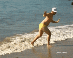 TV gif. From a show on Adult Swim, a man wearing a white baseball cap and a yellow speedo scurries with his arms out away from a wave onto the shore.
