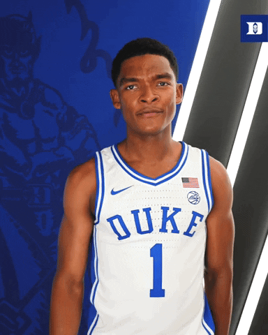 Sports gif. Caleb Foster, a player on the Duke basketball team looks at us with a serious expression on his face, furrowing his brow. He gets closer and closer to the camera, peering intently.