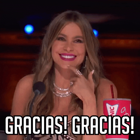 Reality TV gif. Actress Sofia Vergara beams from her judge's seat on America's Got Talent, claps her hand over her heart, and says "Gracias!"