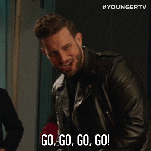TV gif. Nico Tortorella as Josh on Younger looks out and to the side with excitement, shouting "go, go, go, go!" which appears as text.