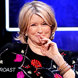 TV gif. Martha Stewart on Comedy Central Roasts nods with a smile, her fingers to her mouth. She looks at someone off screen and raises her eyebrows slightly in a knowing nod and grin, and then turns her gaze the other direction. 