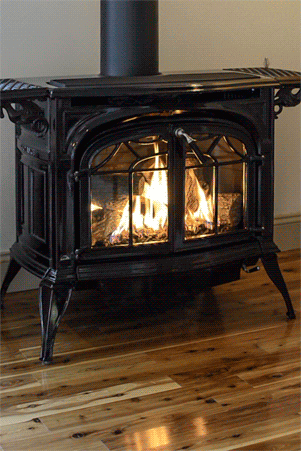 a black wood stove is sitting on a wooden floor .