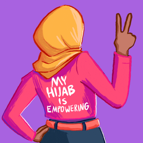 Illustrated gif. A woman wearing a hijab stands with the back of her pink shirt showing that says, "My hijab is empowering." One hand is on her hip and the other is throwing a peace sign up and down. 