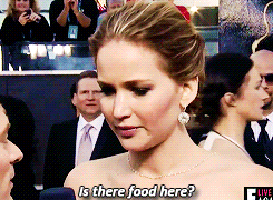 Celebrity gif. Jennifer Lawrence on a red carpet event leans into a reporter's microphone and asks, "is there food here?" which appears as text.