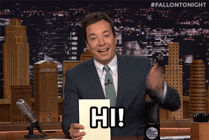 Tonight Show gif. Jimmy Fallon sits at his desk, holding a piece of paper in one hand and waving with the other, saying "Hi!"