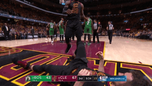 Sports gif. Lebron James in the Miami Heat helps another teammate off the ground, clasping his hands and pulling him up.