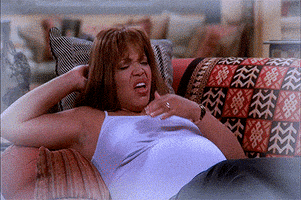 TV gif. A scene from My Wife and Kids. Damon Wayans looks shocked as he catches a baby in his arms after a pregnant woman lying on the couch, coughs.
