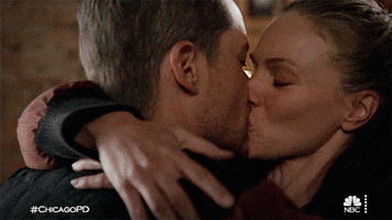 TV gif. Tracy Spiridakos as Upton and Jesse Lee Soffer as Halstead on Chicago PD kiss passionately on the mouth.