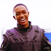 Movie gif. Lee Thompson Young as Jett in The Famous Jett Jackson. He throws a charming smile out at the crowd before pointing at us and his wide smile never breaks.