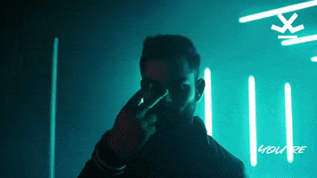 Ad gif. Virat Kohli walks through a green-glowing passageway looking and gesturing with his two fingers that he has his eyes on us. Text appears, "You're one of us," and the WROGN Tribe logo appears in the top corner.