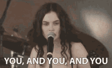 Celebrity gif. Singer is crooning onstage as she stares out into the audience, pointing at certain people while singing her lyrics of, "You, and you, and you."