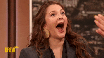 TV gif. Drew Barrymore on the "Drew Barrymore Show" with her mouth dropped fully open and eyes wide in an awkwardly over-the-top reaction to someone gesturing just off screen. 