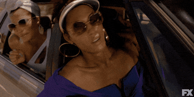 TV gif. Michaela Jae Rodriquez as Blanca, Indya Moore as Angel, Dominique Jackson as Elektra, and Hailie Sahar as Lulu on Pose are all in a car singing, with Elektra driving. Blanca, Indya, and Lulu stick their heads out of the car as they sing.