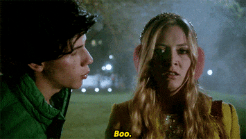 TV gif. Billie Lourd as Chanel #3 and Nick Jonas as Boone in Scream Queens. Boone pops up next to Chanel #3 and says, "Boo." She turns away in fright and runs away, screaming.