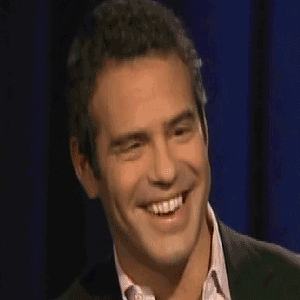 Celebrity gif. Andy Cohen playfully grins and happily nods.