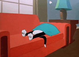 Cartoon gif. Cat sleeps very still on a couch, covering its head with a pillow. Above the pillow is a single feather that floats up and then down as if being propelled by the cat’s snoring.