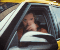 Sponsored gif. Man in the driver’s seat of a yellow vehicle tips two fingers away from his face in a casual salute. Text reads, “Laters.”