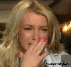 Celebrity gif. Britney Spears cries, leaning back and covering her face with her hands.