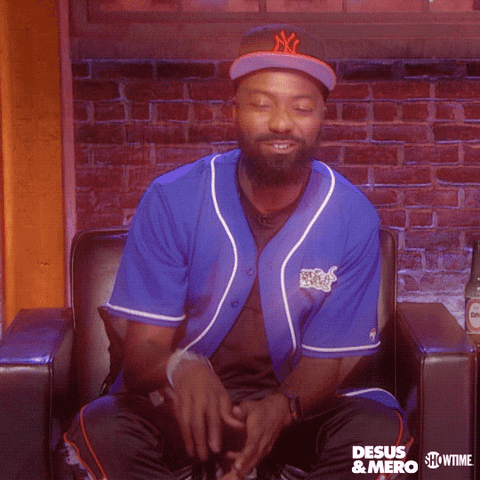 TV gif. Desus Nice from Desus and Mero gives a thumbs down and his thumb is overlayed by a neon pink thumbs down. He shakes his head while smiling.