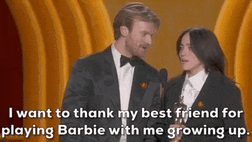 Oscars 2024 gif. Billie Eilish and Finneas O'Connell win Best Song. O'Connell looks proudly at Eilish, who says, "I want to thank my best friend for playing Barbie with me growing up."