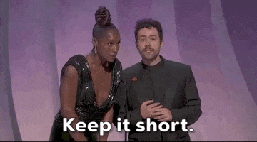Oscars 2024 gif. Issa Rae backs up from the microphone while Ramy bends slightly down, stares at us, and says, "Keep it short."