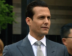 Man dressed in suit (character from TV show suits - Harvey Specter), rolling eyes and turning head around