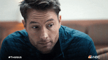 TV gif. Justin Hartley as Kevin in This is Us nods his head and holds up a coffee cup as if in a toast. 