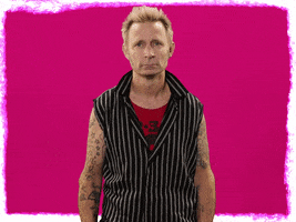 Celebrity gif. Mike Dirnt of Green Day slams a fist into his forehead with a look of annoyance. 