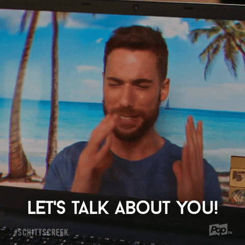 Gif of Ted from Schitt's Creek on a video call in front of an island resort backdrop saying "let's talk about you"
