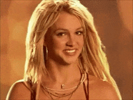 Celebrity gif. Britney Spears smiles at us and gives a thumbs up.