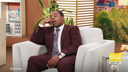 TV gif. Kenan Thompson as Kenan Williams in Kenan sits in an armchair and snoozes with his cheek resting on his hand.