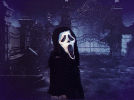 Video gif. A woman wears the Scream mask in front of a graveyard background and does body rolls continuously while looking at us. 