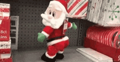 Video gif. An animatronic toy Santa with a jolly big booty playfully dances and bounces on a store shelf.