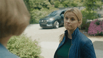 TV gif. Reese Witherspoon, as Madeline in Big Little Lies, raises her eyebrows and shrugs her shoulder as if to say, “Oh well.”