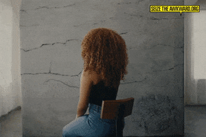 Video gif. Megan Thee Stallion seated away from us in a chair turns to look over her shoulder in our direction with a serious expression. Text, "Check in on your friends even the *quote* strong ones."