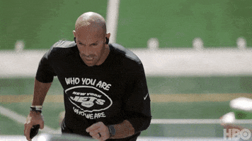 Video gif. Slow motion video of Robert Saleh, head coach of the New York Jets, running up the steps of an empty New York Jets stadium, looking strong and focused. 