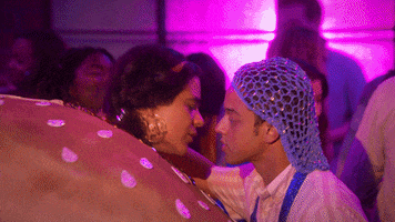 TV gif. Dressed as a cheeseburger, Jessica Marie Garcia, as Jasmine, passionately kisses Jason Genao, as Ruby, on the dance floor.