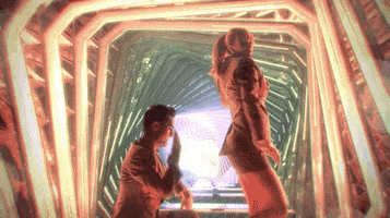 Music video gif. From the video for "Me," Taylor Swift walks in place while Brendon Urie kneels behind and slaps her feet.